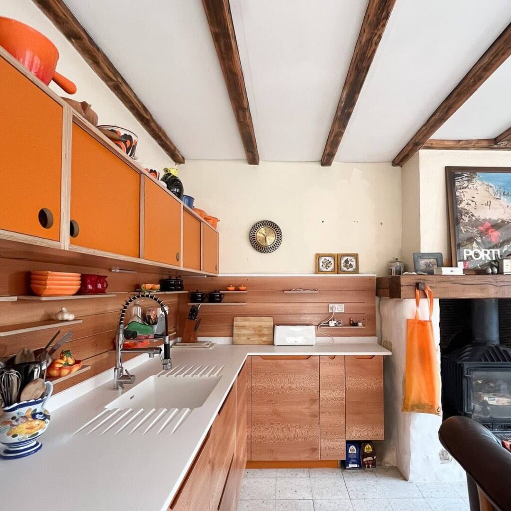 2. Retro Charm: Orange Cabinets in a Warm Wood Kitchen