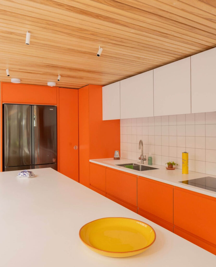 4. Sleek and Minimal: All-Orange Cabinets with Scandinavian Flair
