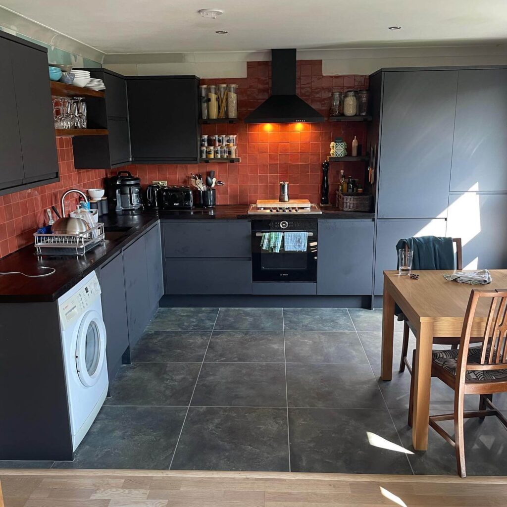 20. Rustic Revival: Red Tiles and Black Cabinets