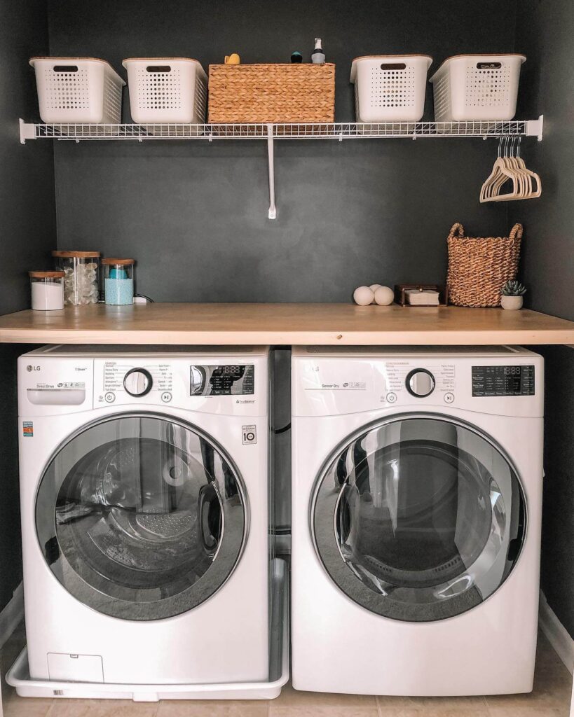 7. Moody Laundry Nook with Matte Black Walls and Open Shelving