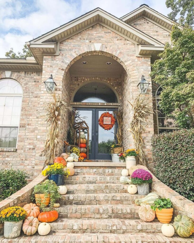 1. Layered Front Porch Decor with Pumpkins and Mums